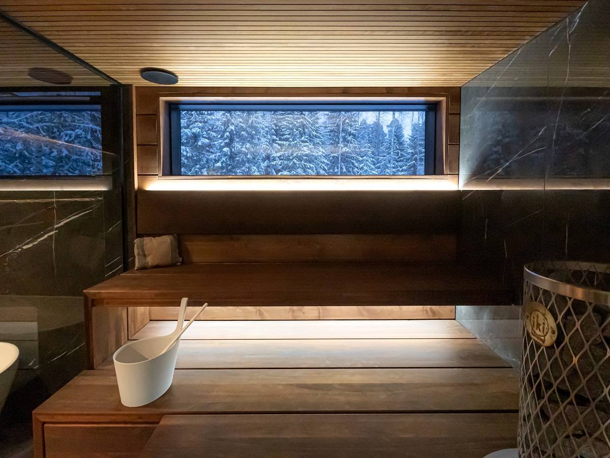 Eclairage du sauna indirectement par l'arrière du dossier et sous le plafond, filmé de face